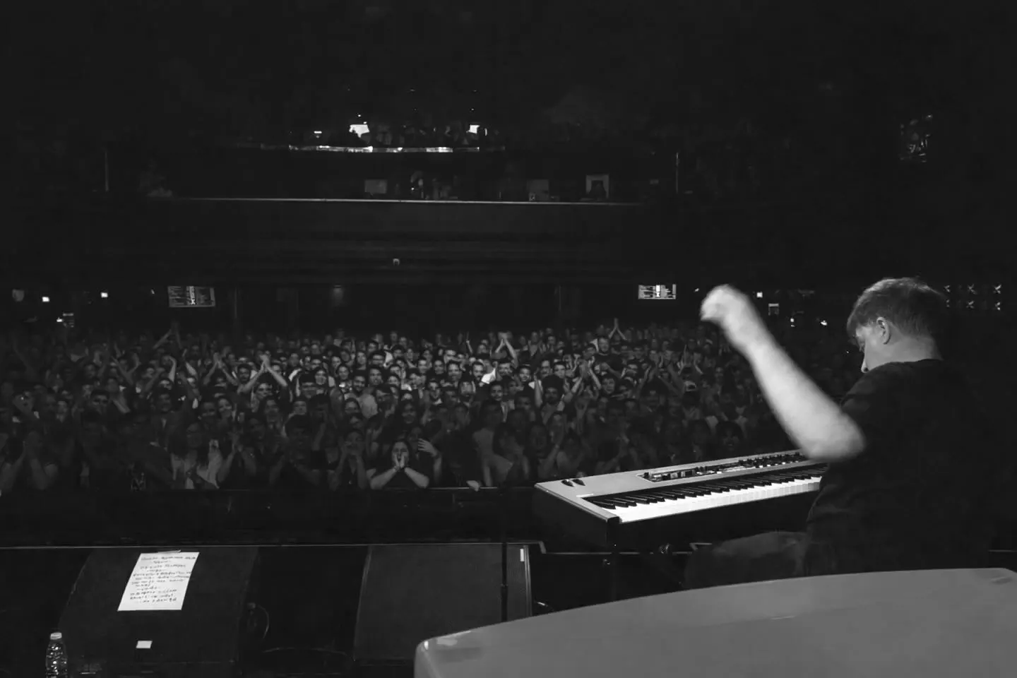 Público visto desde el escenario, con un piano a la derecha