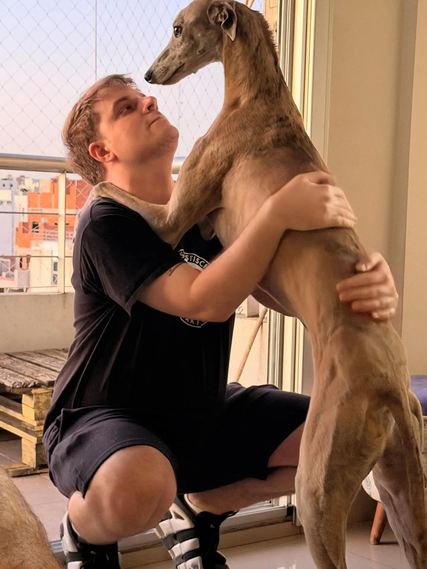Lucas abrazando a Ñoqui, un galgo